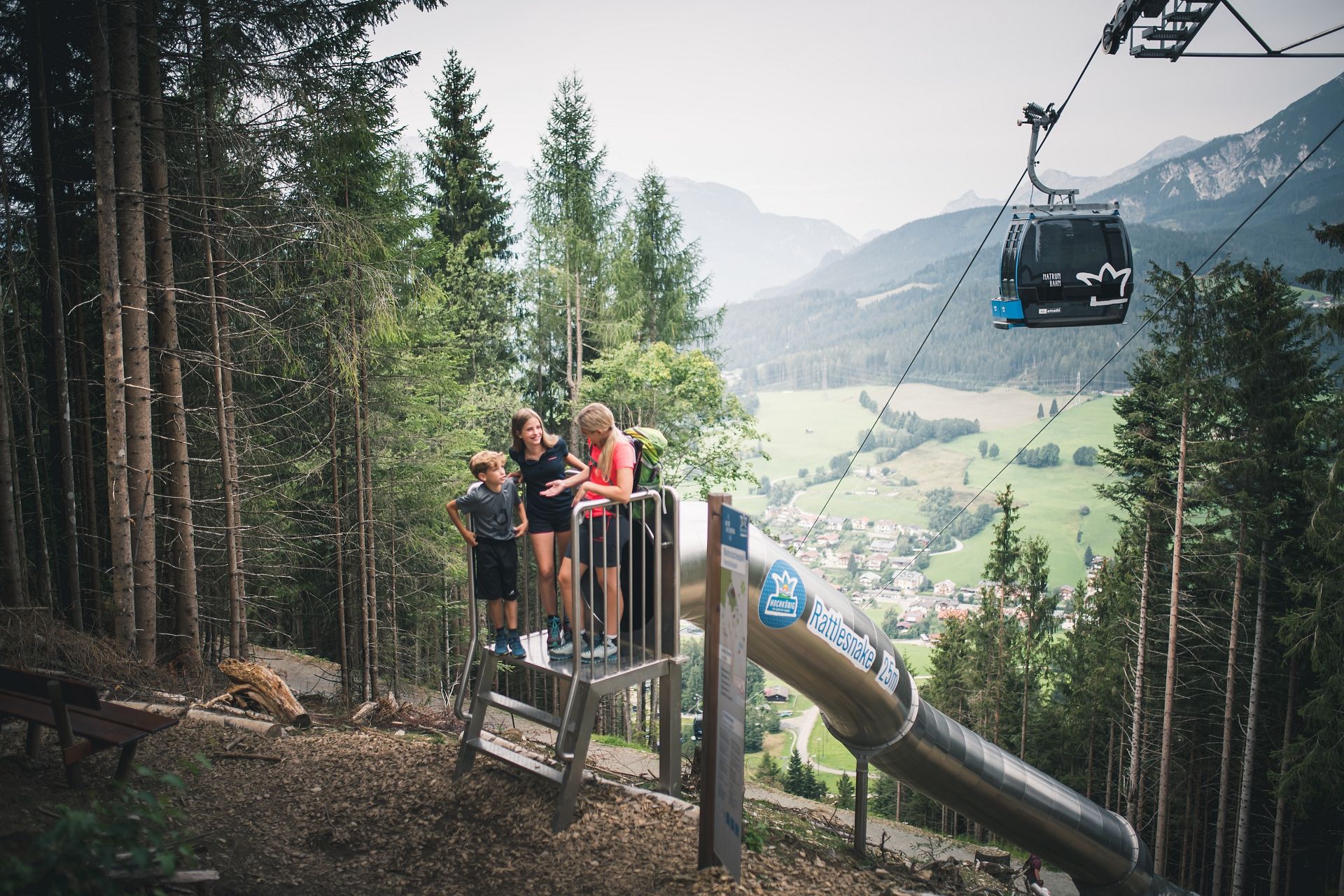 Familie am Waldrutschenpark Natrun mit Blick auf Maria Alm