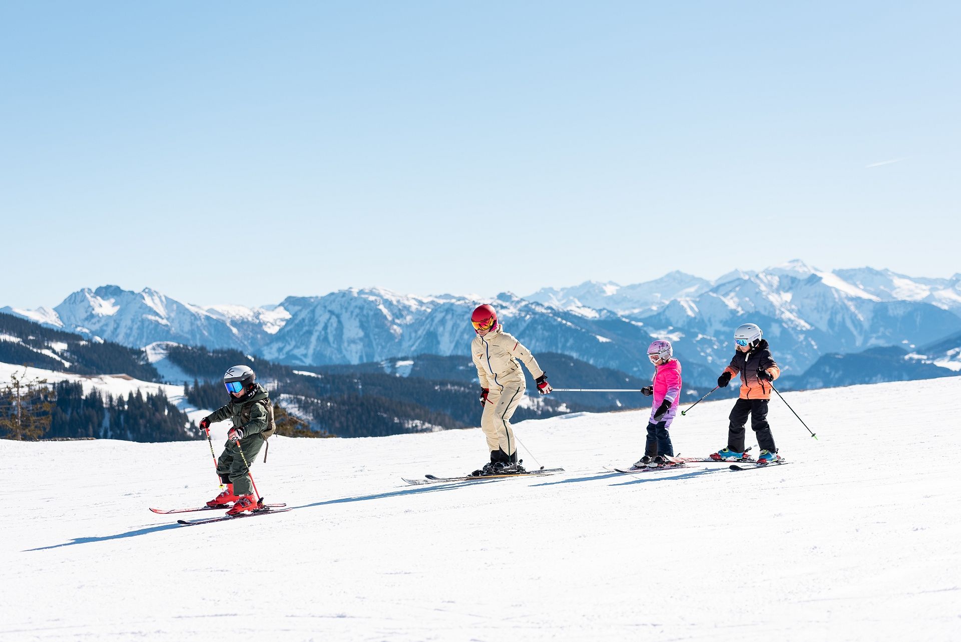 Familie beim Skifahren vor dem Alpenpanorama am Hochkönig