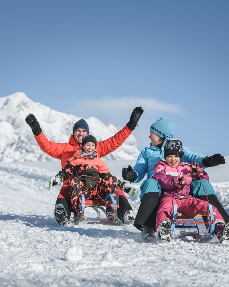 Familie beim Rodeln in der Region Hochkönig