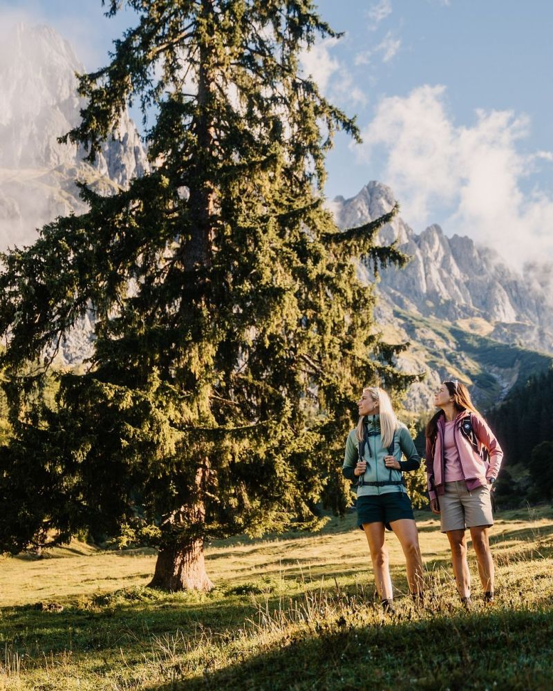 Zwei Wanderinnen auf einer Almwiese mit Blick zum Hochkönig