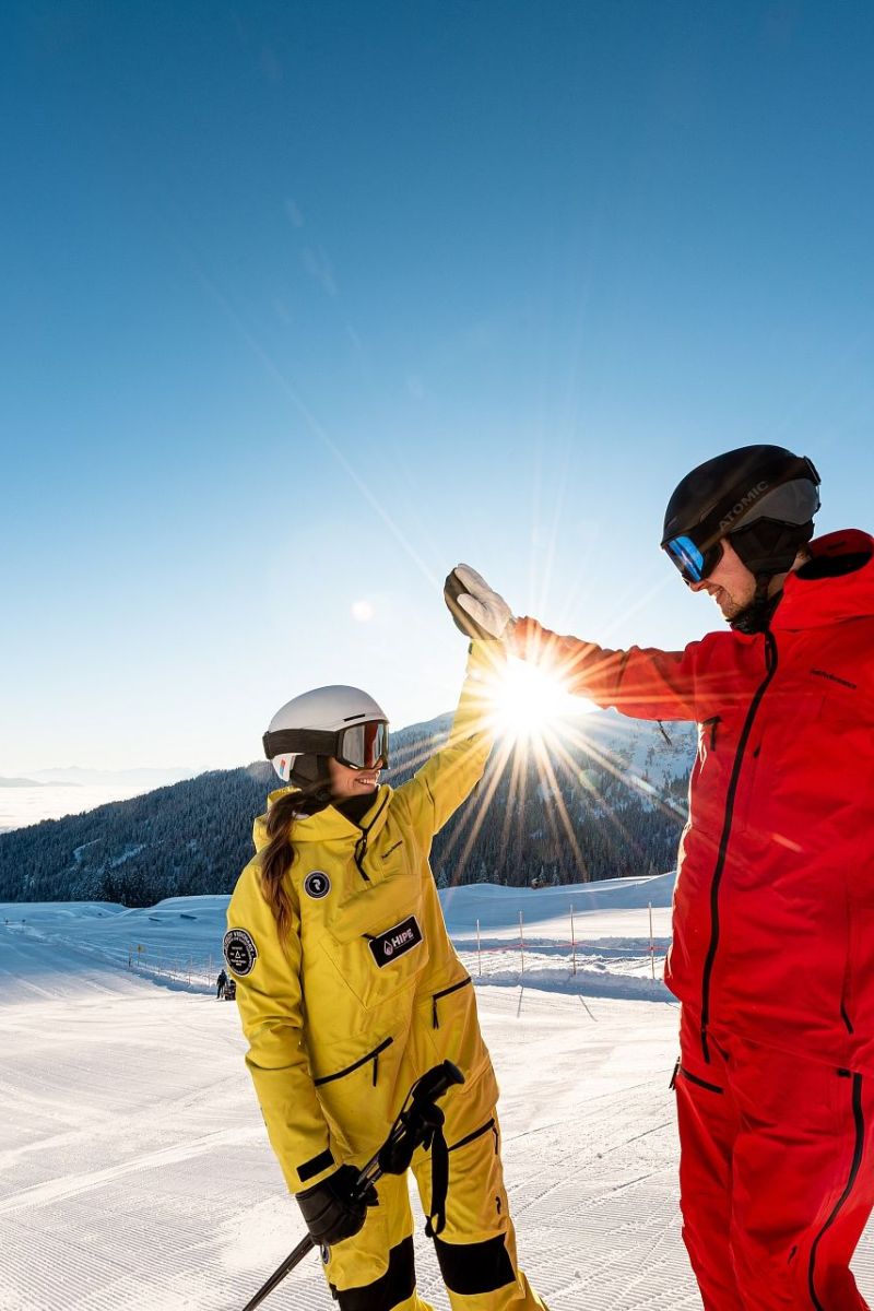Paar beim Skifahren auf sonniger Piste am Hochkönig