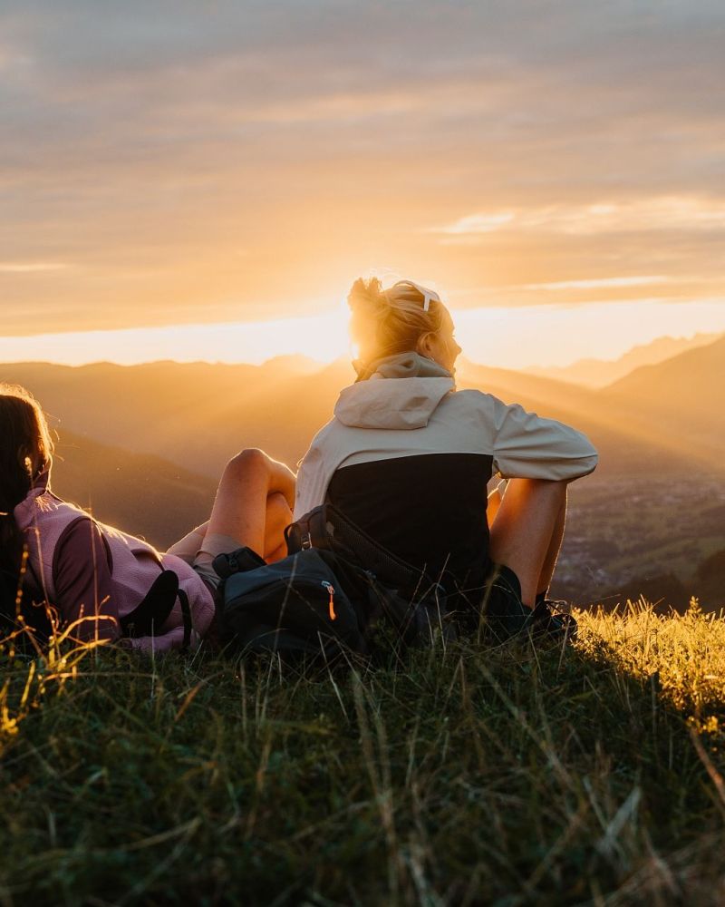 Zwei Wanderinnen beim Sonnenuntergang in den Bergen