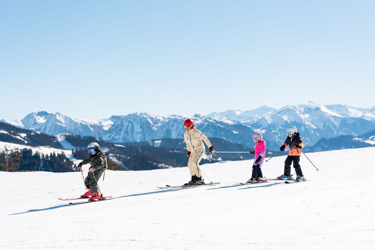 Familie beim Skifahren vor dem Alpenpanorama am Hochkönig