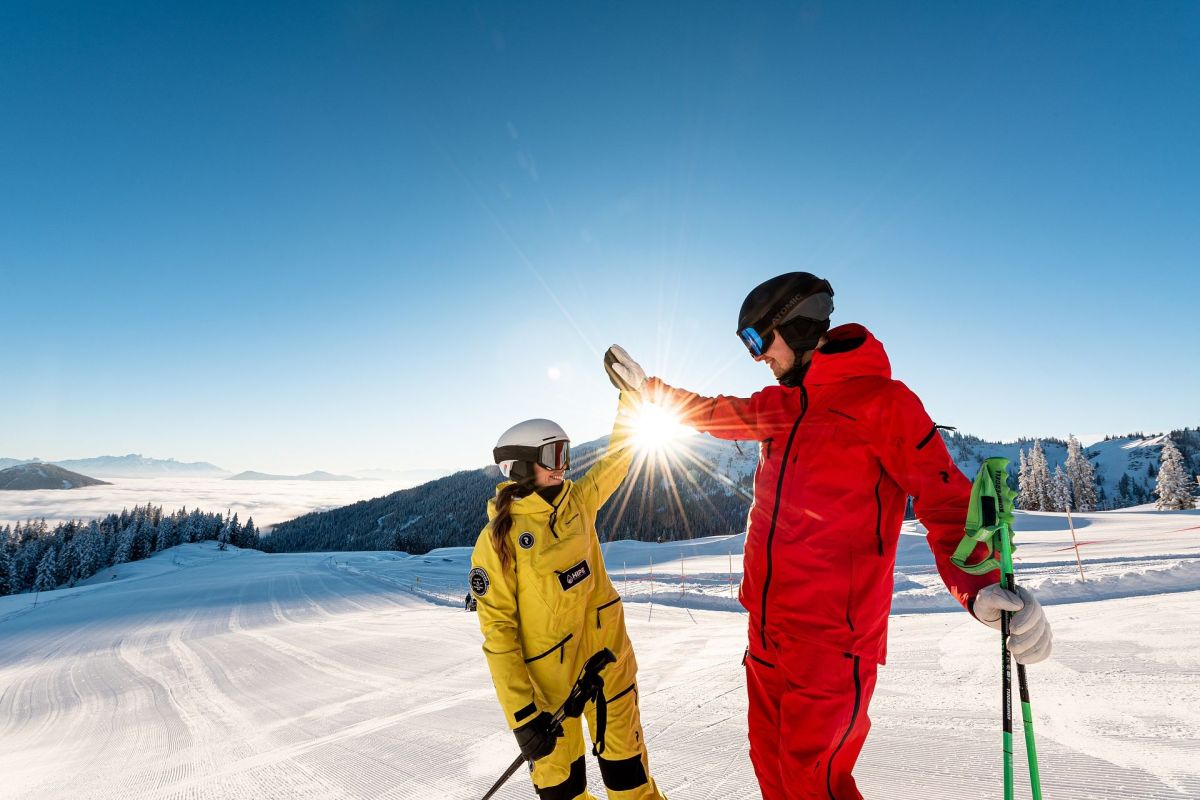 Paar beim Skifahren auf sonniger Piste am Hochkönig