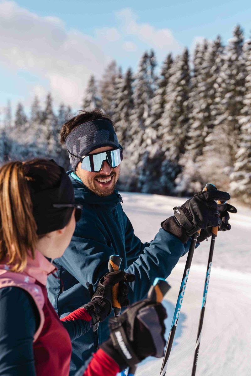 Zwei Langläufer bei einer Pause in verschneiter Winterlandschaft