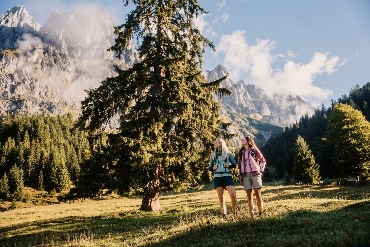 Zwei Wanderinnen auf einer Almwiese mit Blick zum Hochkönig