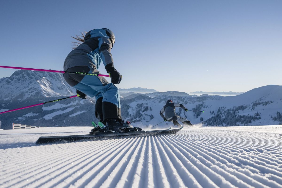 Zwei Skifahrer auf frisch präparierter Piste am Hochkönig