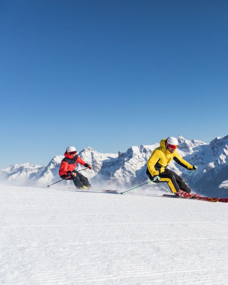 Zwei Skifahrer beim Carven vor dem Hochkönigmassiv